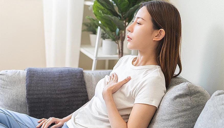 Person experiencing acid reflux symptoms with burning chest discomfort
